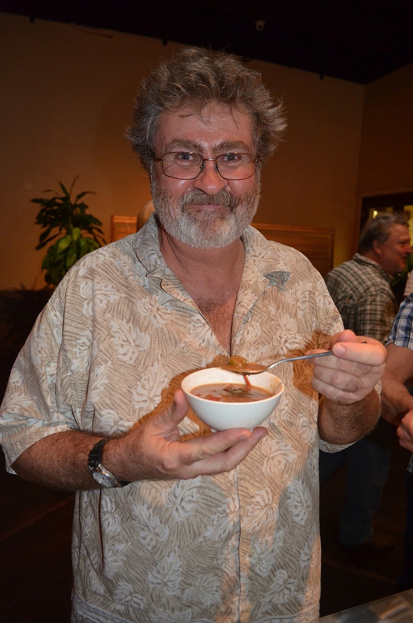 Rich McDonald taste tests the gumbo after performing with the Gumbo Boogie Band.