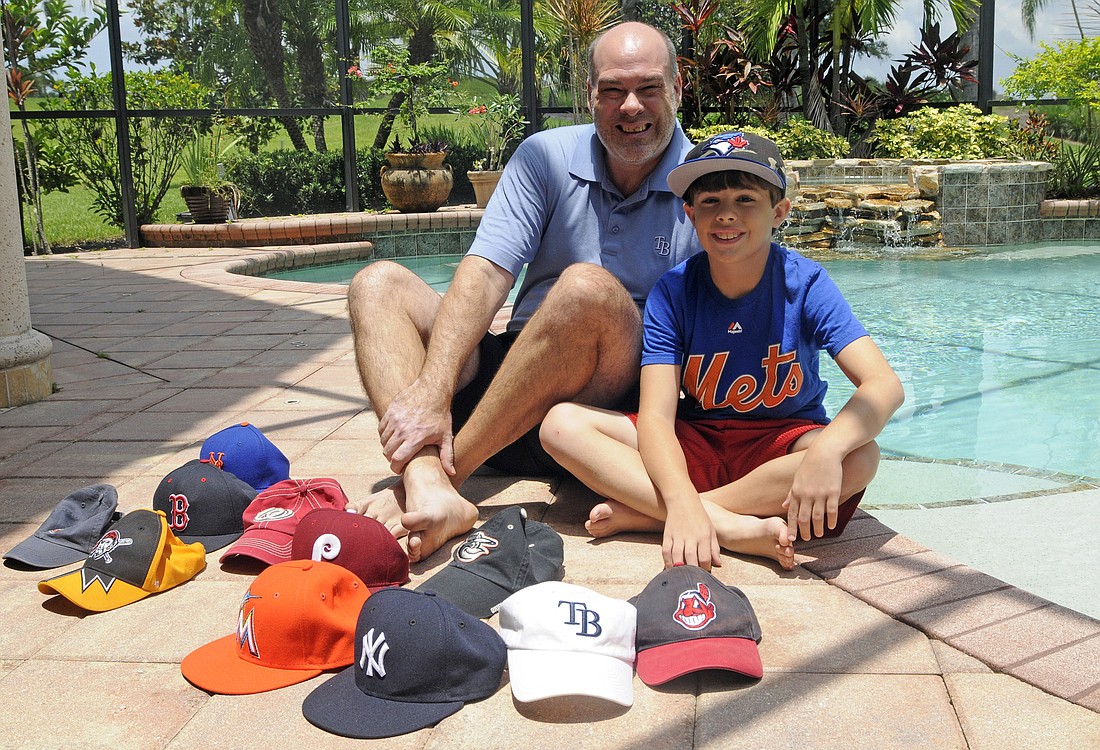 Chris Hill and his 10-year-old son, Drew, have a baseball hat from each of the stadium's they've visited.