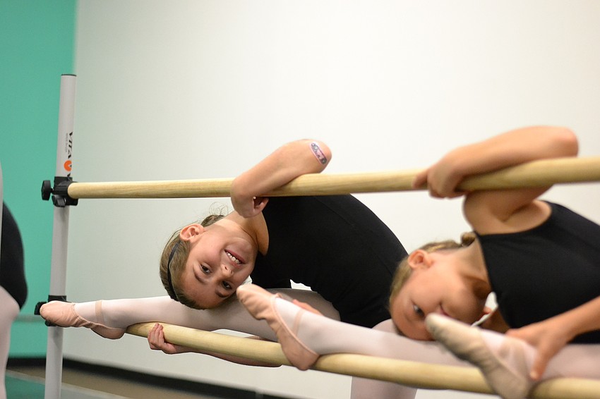 Lila Tack peaks between the barres during warm ups.
