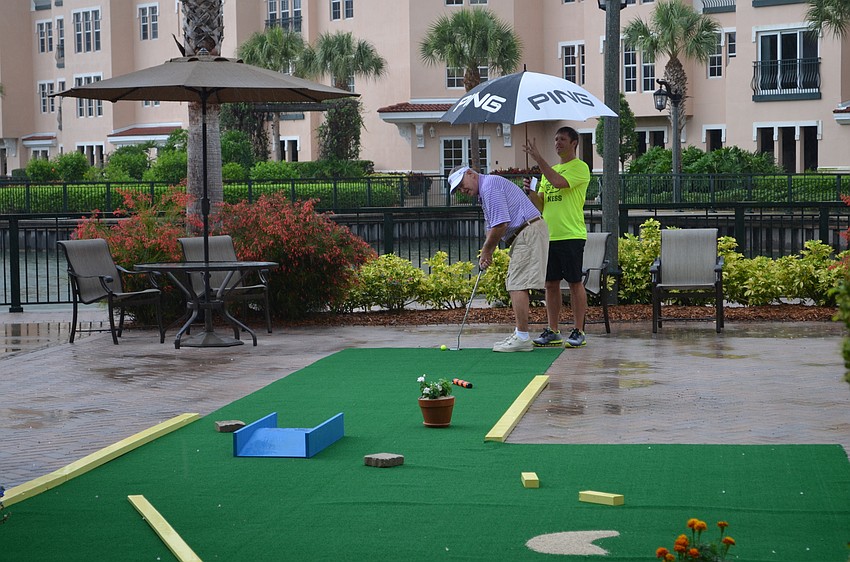Fitness Center Manager Andre LeClair helps out with an umbrella for Dr. Wally Smith.