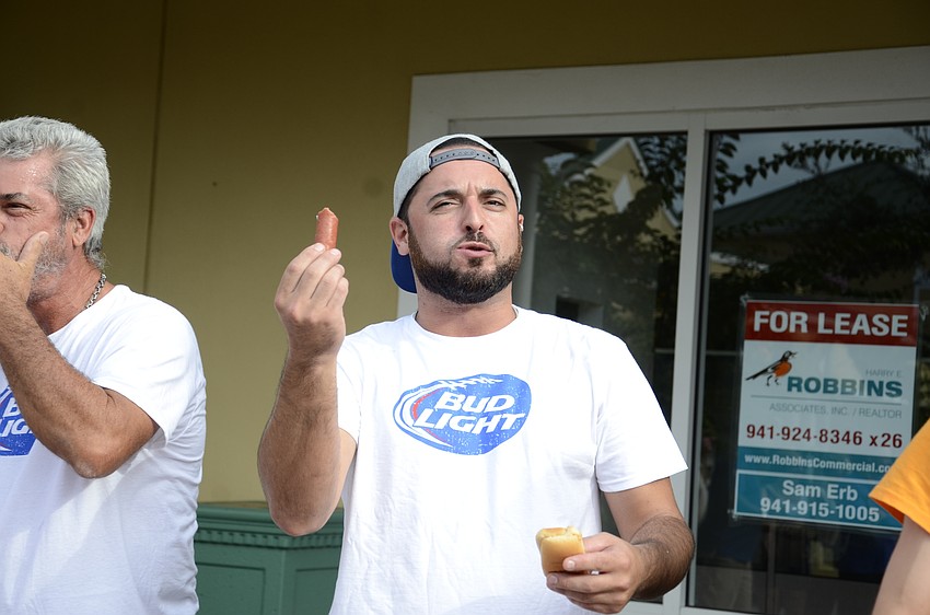 Pete Torrillo shakes a hot dog at the cheering crowd.