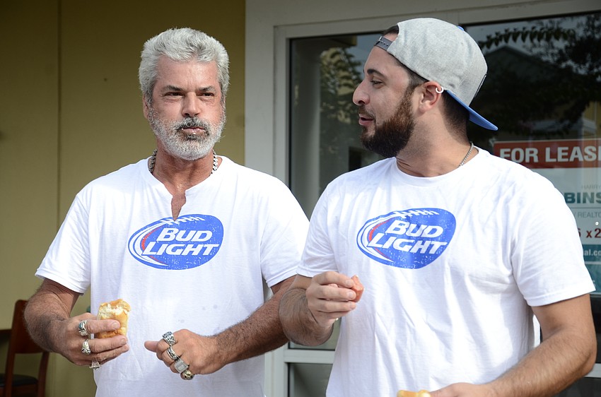 Pete Torrillo and Phil Cruse joke while trying to eat another hot dog.