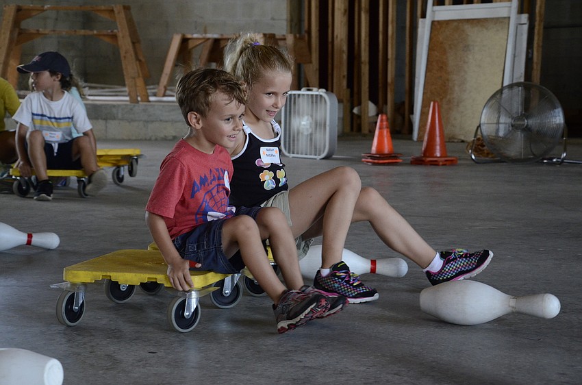 Evan Branson and Madison McCaffery race to knock over a pin.