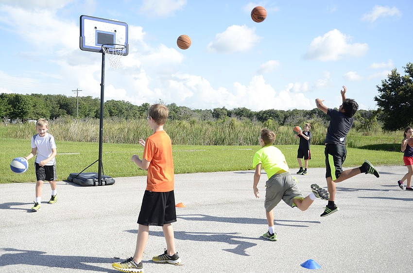 Kids practice shooting the ball at Mega Sports Camp.