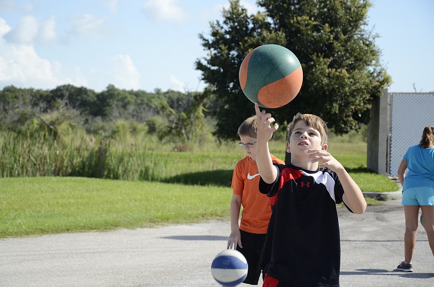 Auggie Kelley tries to spin the basketball on his fingertip.