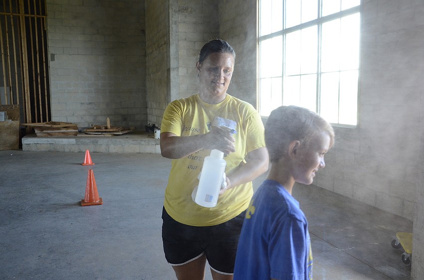 Volunteer Amanda Hirst sprays down Jacob Branson with some mist.