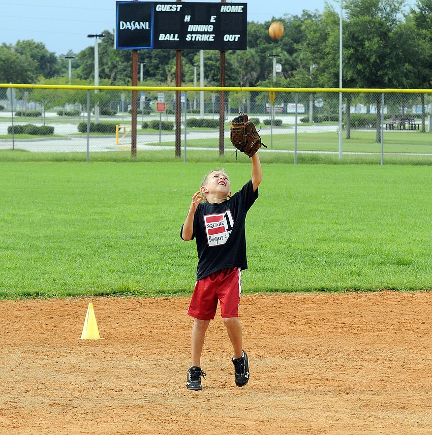 Six-year-old Chase Snelson catches a pop up during a fielding drill.