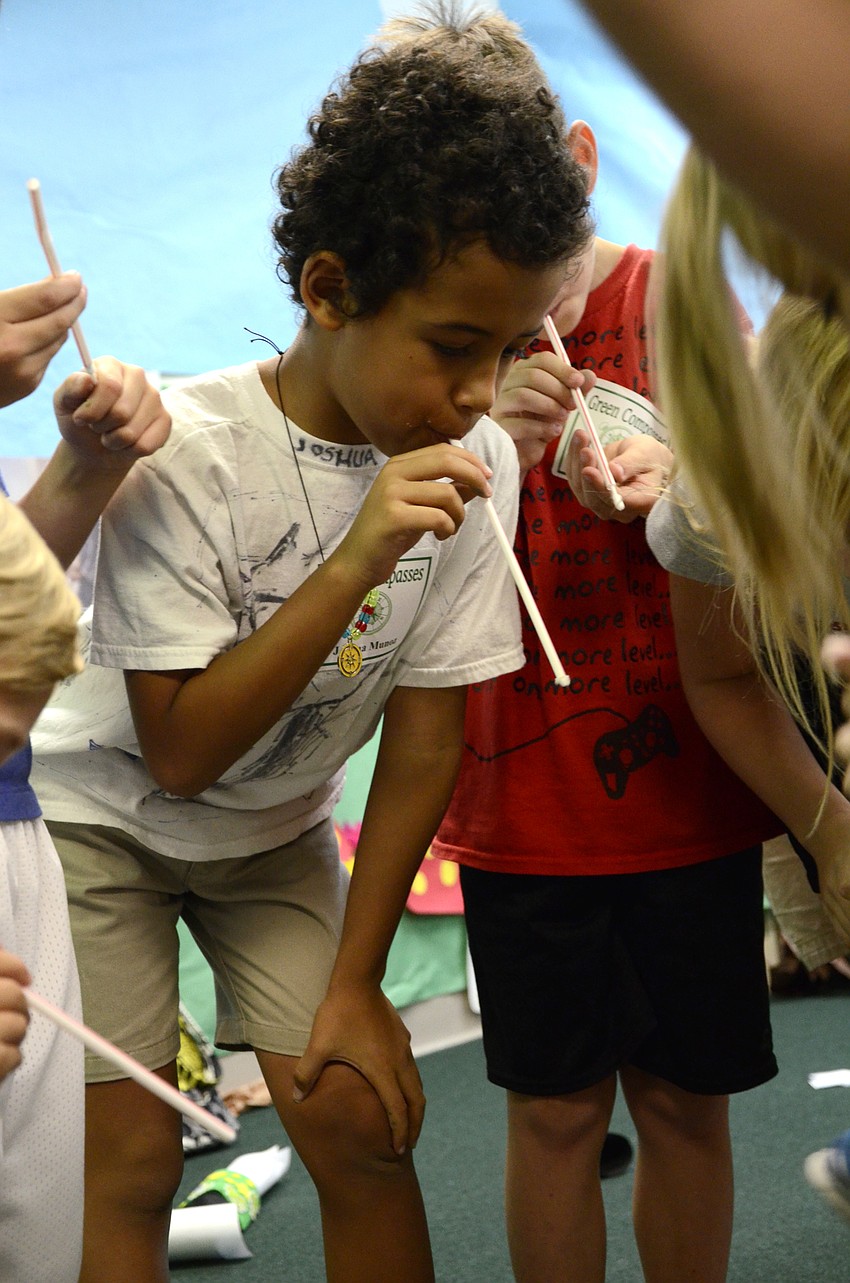 Joshua Munoz tries to hit a target with his straw cotton swab shooter.