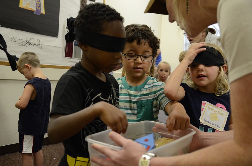 Danny Stratton and Dominik Turner partner up for a game, and Jennifer Freeman helps them pick out an object.