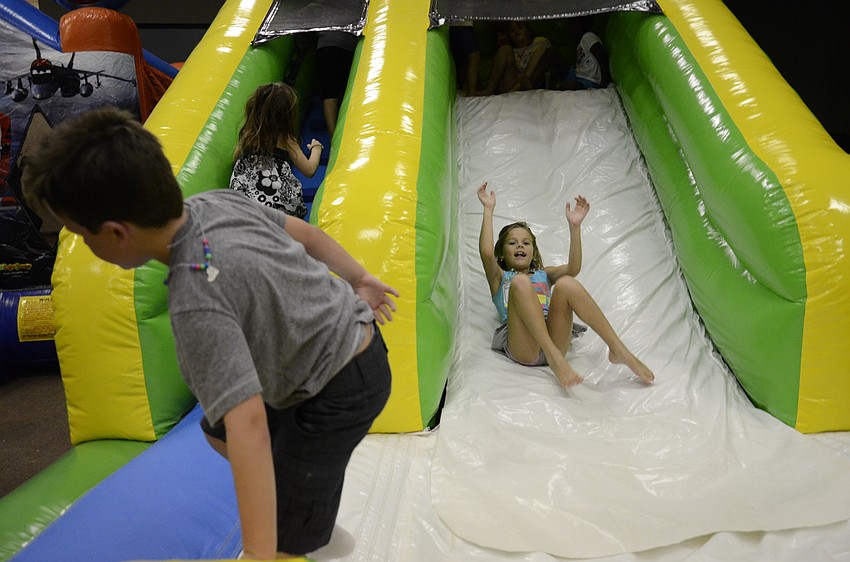 Abby Beach bounces down the inflatable slide.