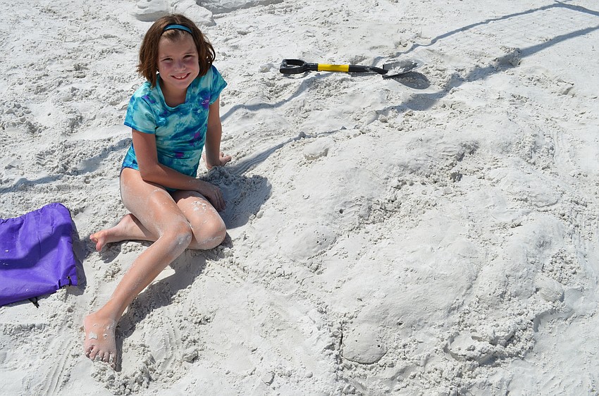 Apple Talbot with her completed sculpture of manatees.