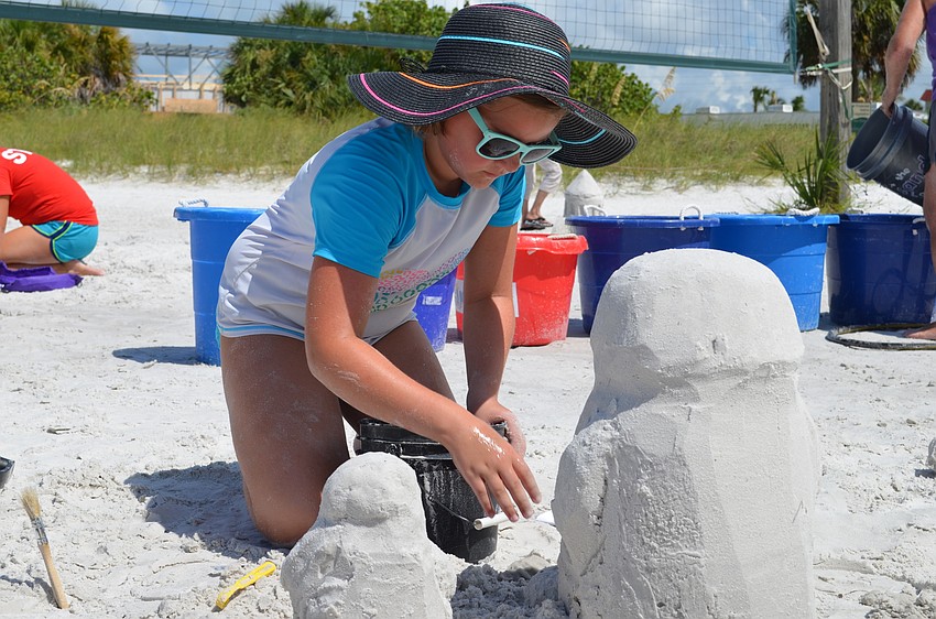 Lily Klemeyer works on her sculpture of a mom and baby penguin.