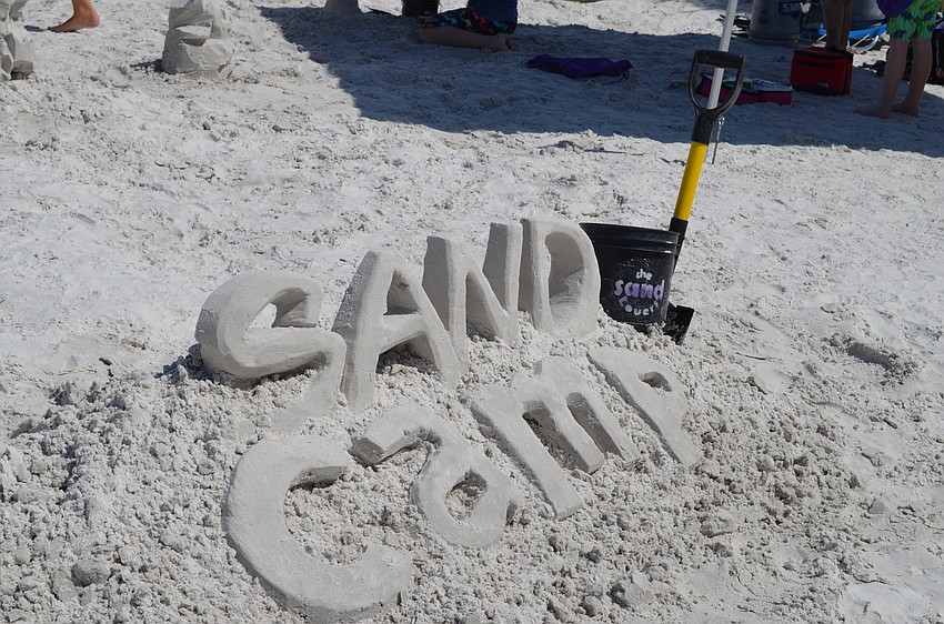 A three-dimensional sand sculpture welcomes campers to the beach.