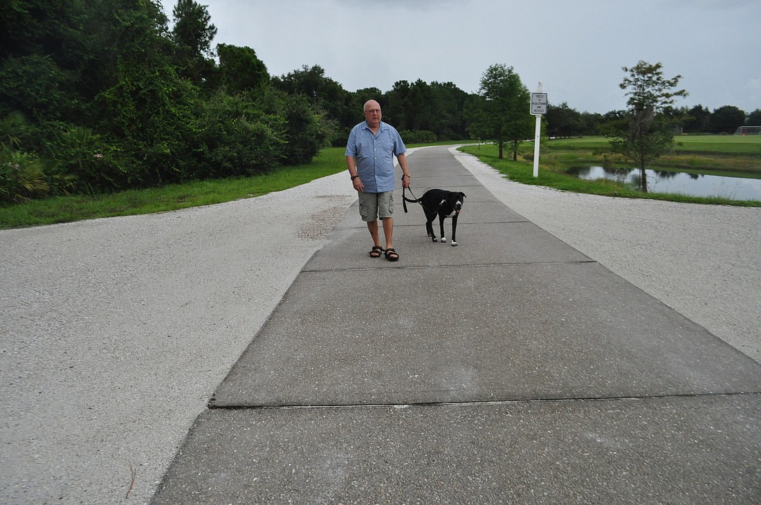 Cliff Kaplan, president of the Lakewood Ranch Dog Park, and his dog, Travis, regularly walk around Greenbrook Adventure Park. At the request of Town Hall, Kaplan's asking fellow dog park members to share the road when they drive  to the park.