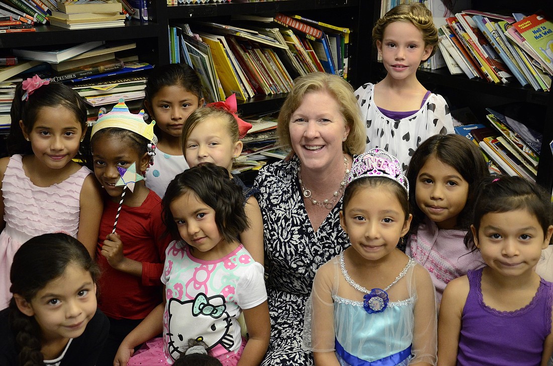 Angie Stringer sits with a group of kindergarten and first-grade girls at a summer program. The girls had a fairy tale day and dressed up like princesses.