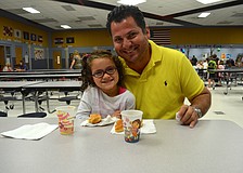 Bariela Orozco and her father, Tito, enjoy donuts and juice.