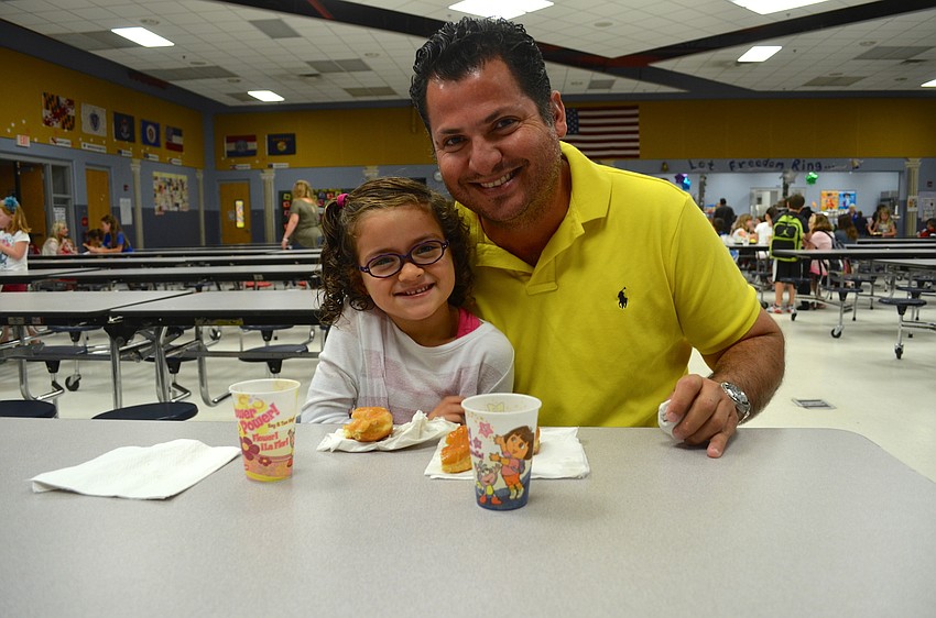 Bariela Orozco and her father, Tito, enjoy donuts and juice.