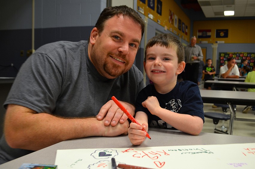 John Kramer and his son, Rhys, sign a 