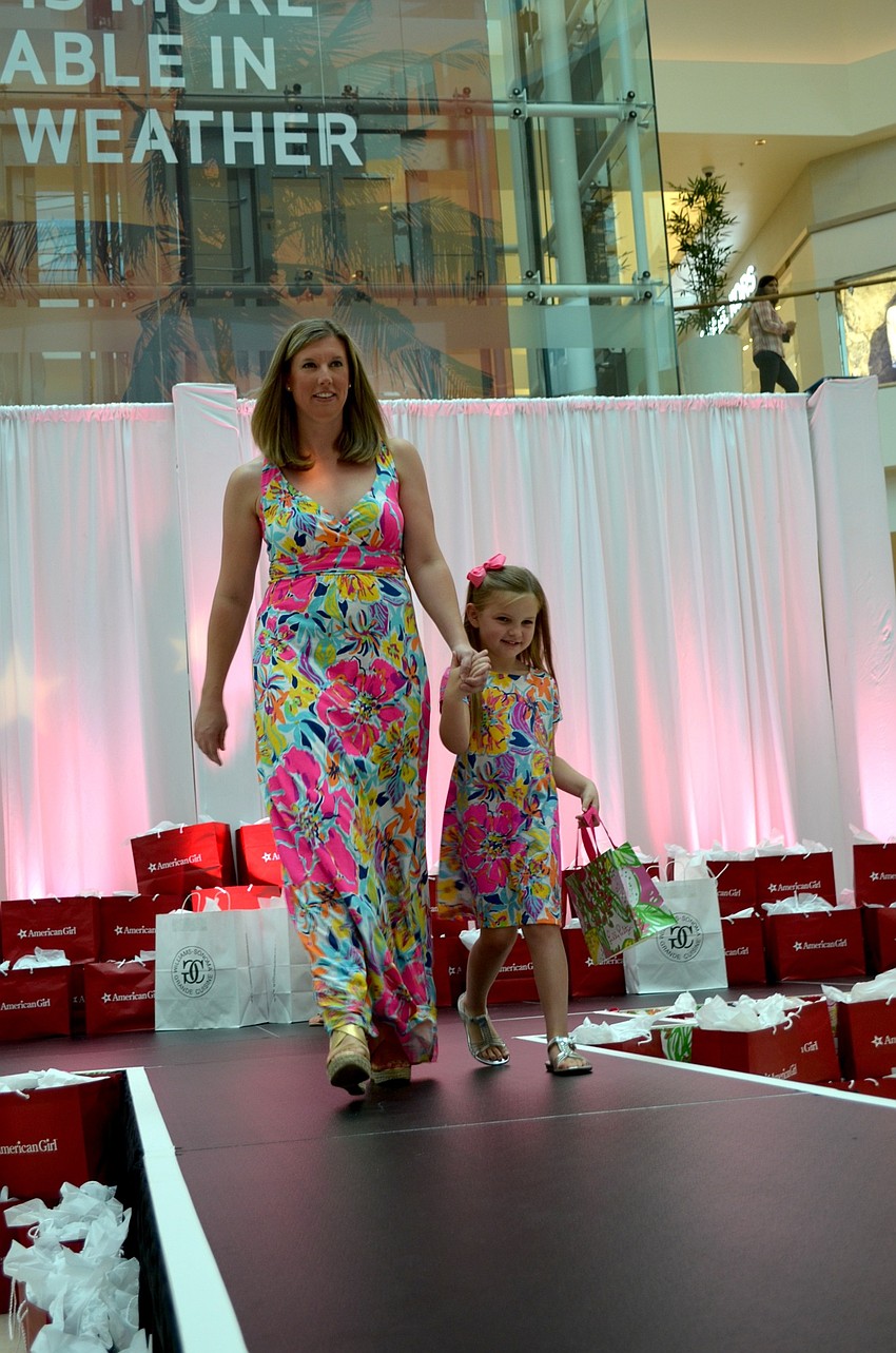 Amanda Gambert and her daughter, Olivia, gracefully strut down the runway.