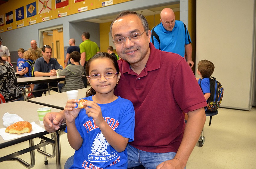 Shalini and Yashveer Rathor enjoy two of the 500 donuts donated for the event.