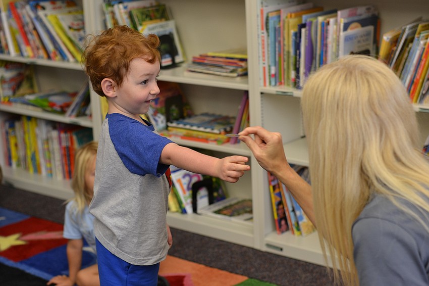 Gideon Hinds receives a sticker for behaving well during story time.