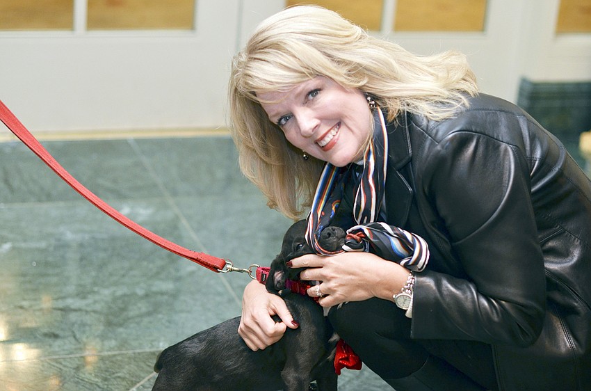 Deborah Vaughan gets puppy kisses from Teddy, at hound mix at the 22nd annual Hot Dogs and Cool Cats â€˜Laugh Your Paws Offâ€™ Gala.
