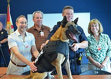 Henry Schneiderman, Chuck Dillin and Leslie Hall pose with Officer Sean Gleason and K-9 Officer Hixon.