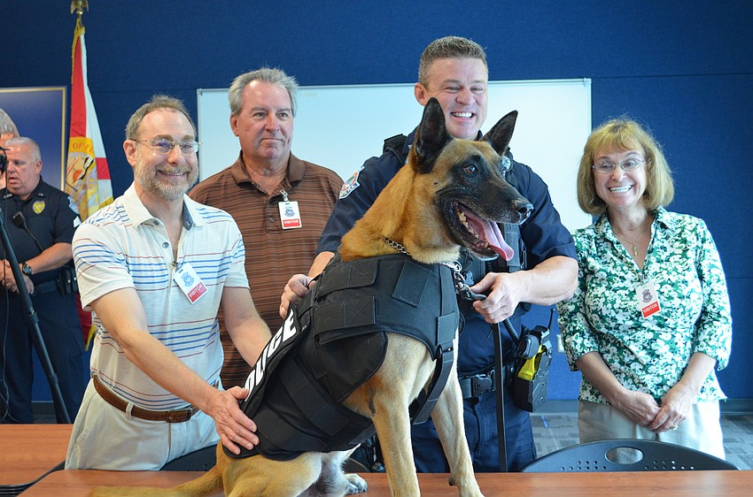 Henry Schneiderman, Chuck Dillin and Leslie Hall pose with Officer Sean Gleason and K-9 Officer Hixon.