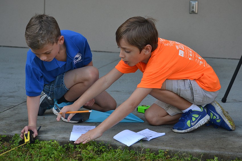 Joseph Harper and Cole Lerner calculate the distance a paper plane flew.