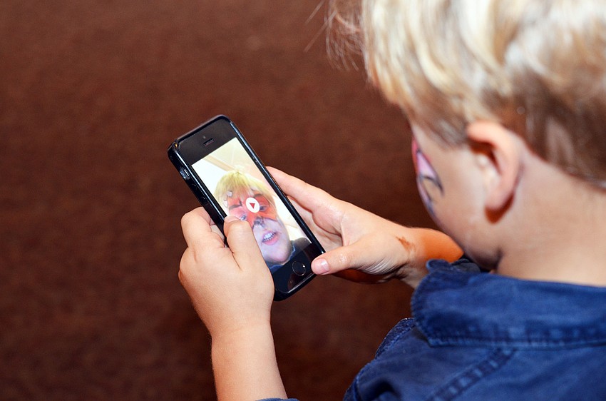Austin Bobb takes a selfie of his face painting.