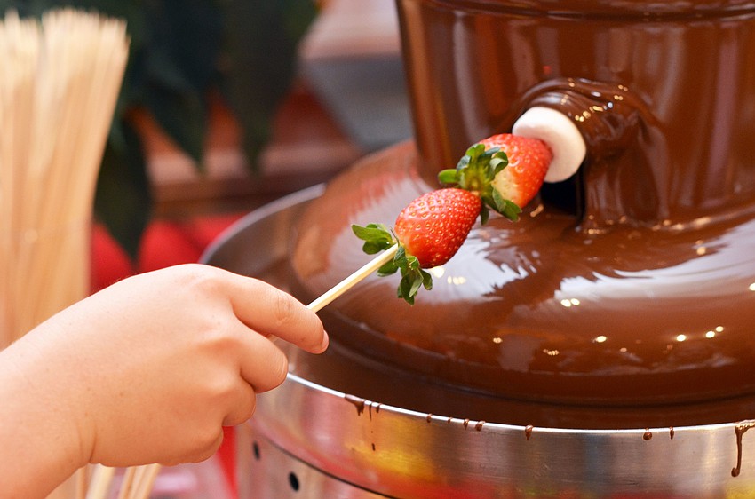 Kids dip marshmallows and fruit in the chocolate fondue foundation at Christmas in Candyland.