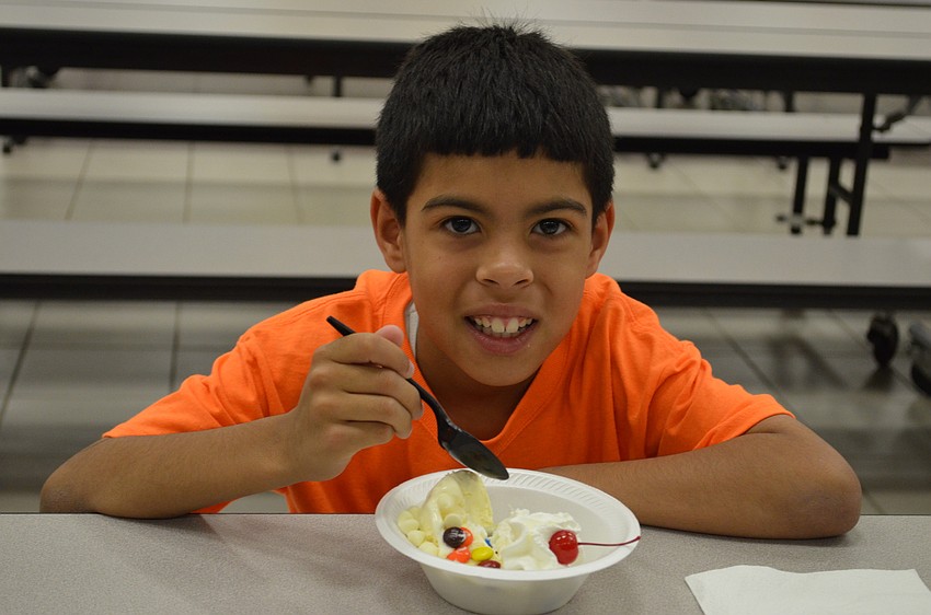 Johan Ortiz enjoys his ice cream sundae topped with M&Ms, white chocolate chips, whipped cream and a cherry.