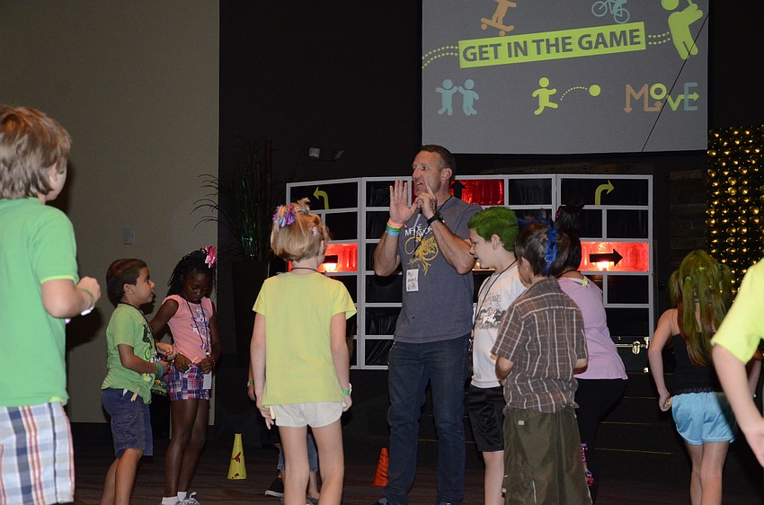 Volunteer Rob Rowe directs children in an indoor version of tag.