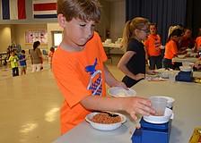 Michael Mauro measures butterscotch chips to add to his sundae.