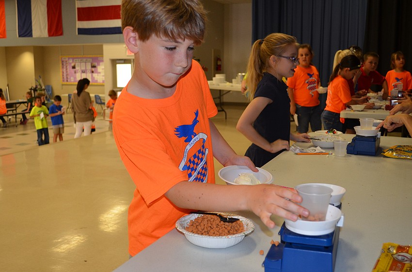 Michael Mauro measures butterscotch chips to add to his sundae.
