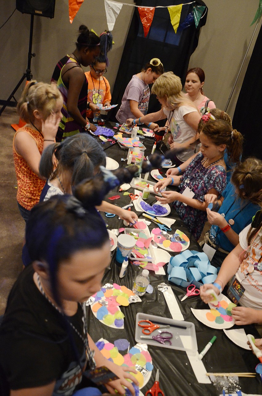 RiverLife vacation Bible school campers make fish with paper plates.