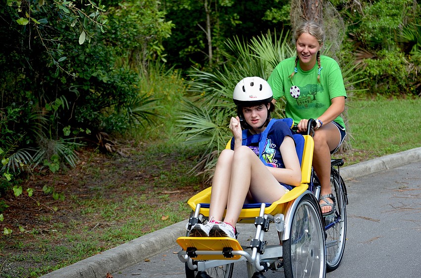 Caroline Imiolek pushes Shannon Punzak on a two-seat bicycle-meets-tricycle.