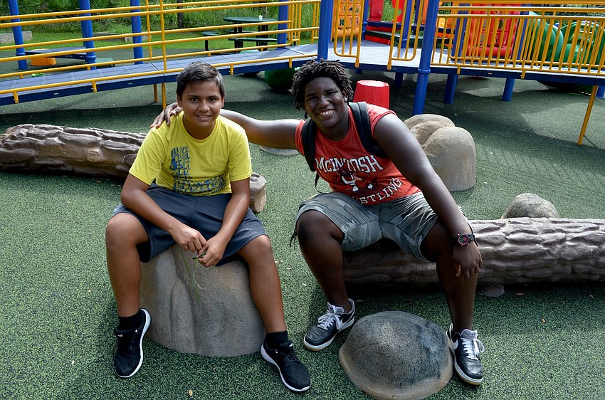Luis Vance and Antwaan Clemons take a time out from playground activities.