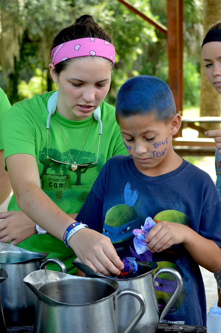 Hailey Barnes and Carmine Serafino finish turning a white piece of clothing into a multi-colored one.