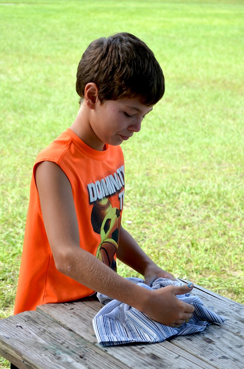 Max Collado wraps his pillow with rubber bands so he can tie dye it later.
