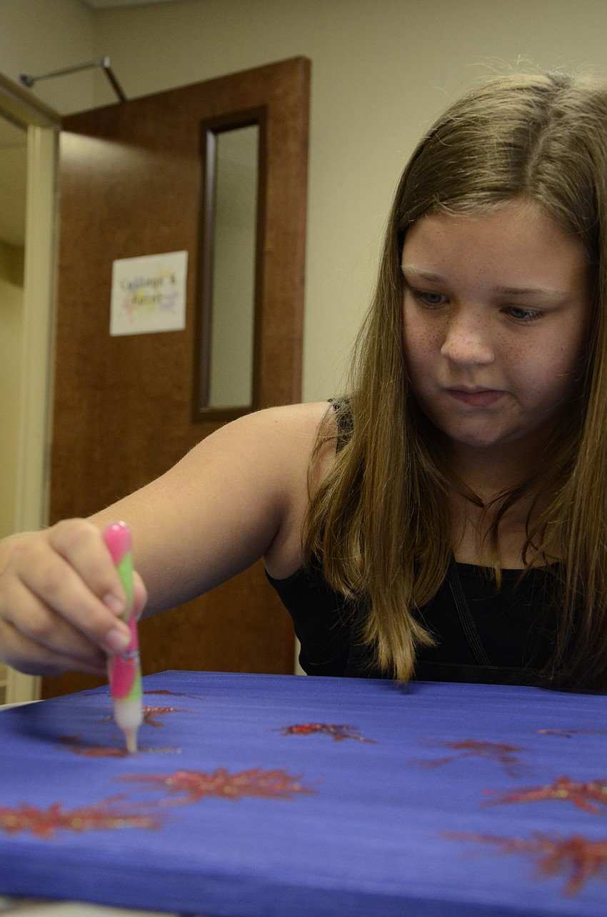 Rachel Mahon paints fireworks for her art project.
