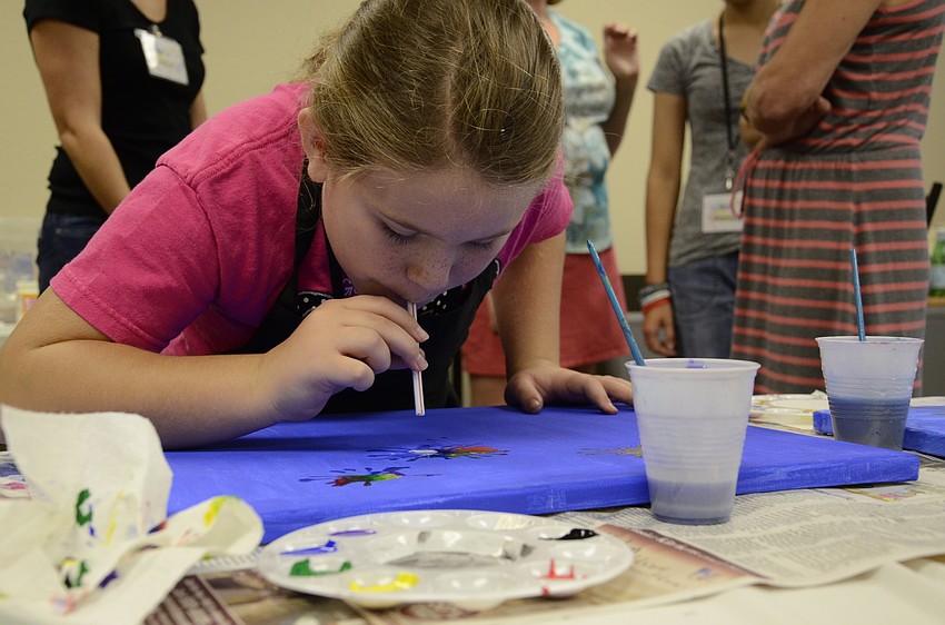 Ava Filewich uses a straw to spread out her paint to look like fireworks.