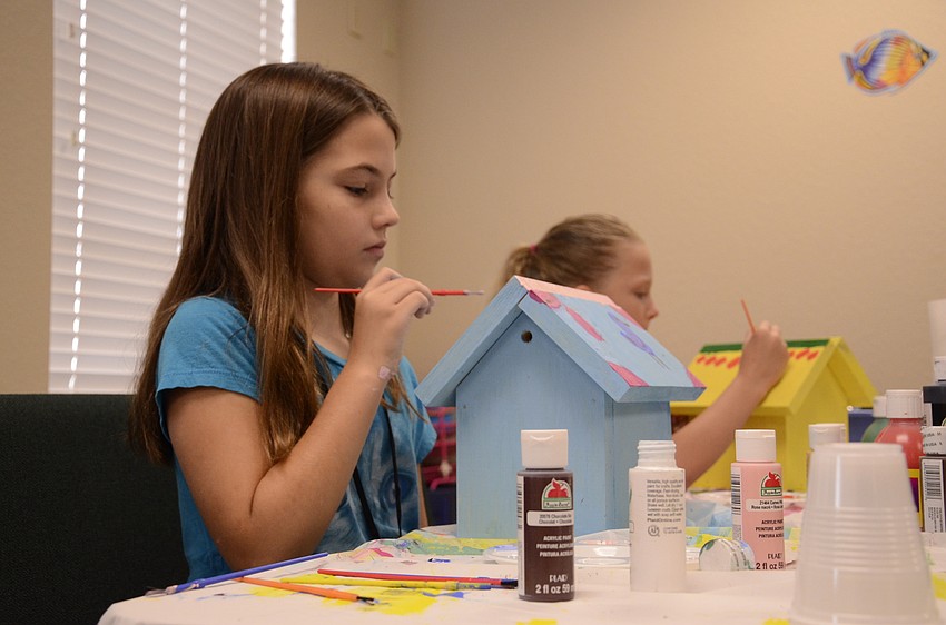 Abby Kagy paints her birdhouse during woodworking class.