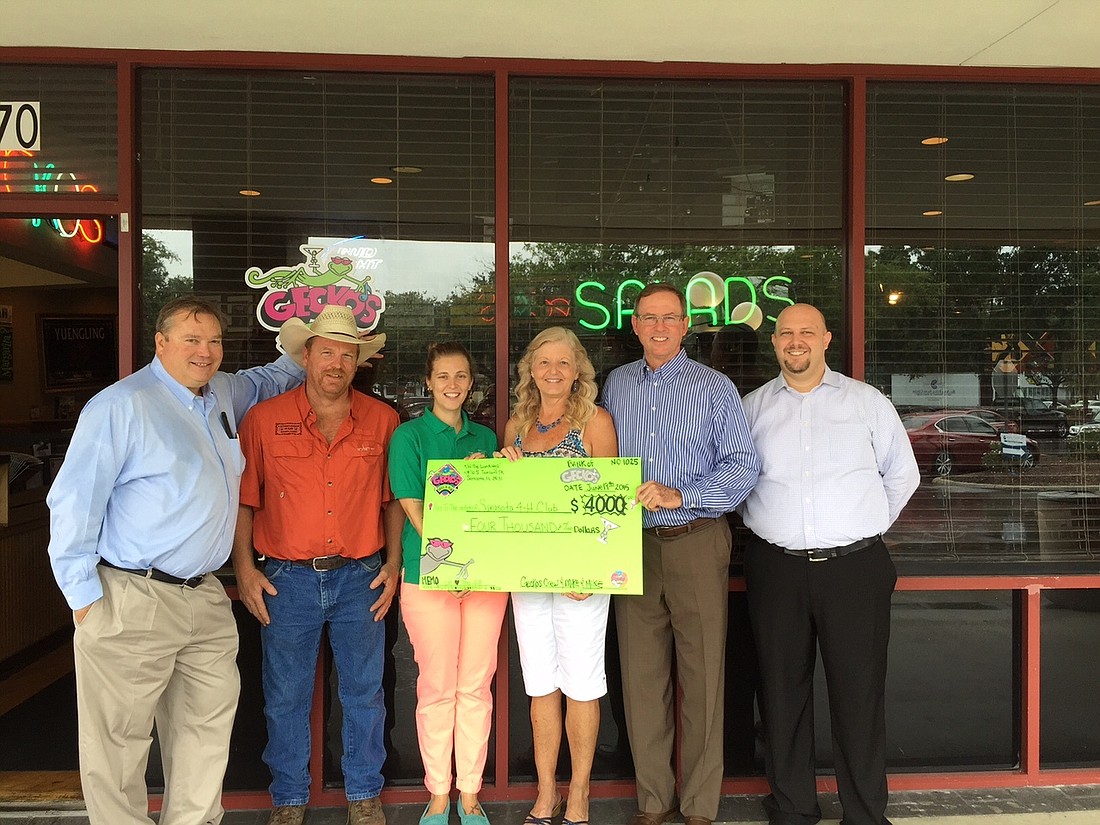 Gecko's Grill & Pub presents a check for $4,000 to Sarasota County 4-H Clubs & Foundation.