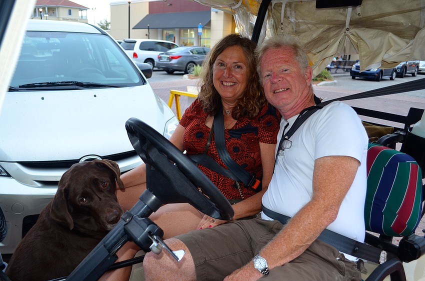 Godiva, Lynn and Brad Schramek enjoy a front-row view from their golf cart.