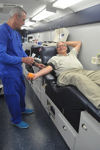 Fran Fougere preps John Holtzermann before a blood donation at Aging in Paradise's health fair on March 9, 2013.