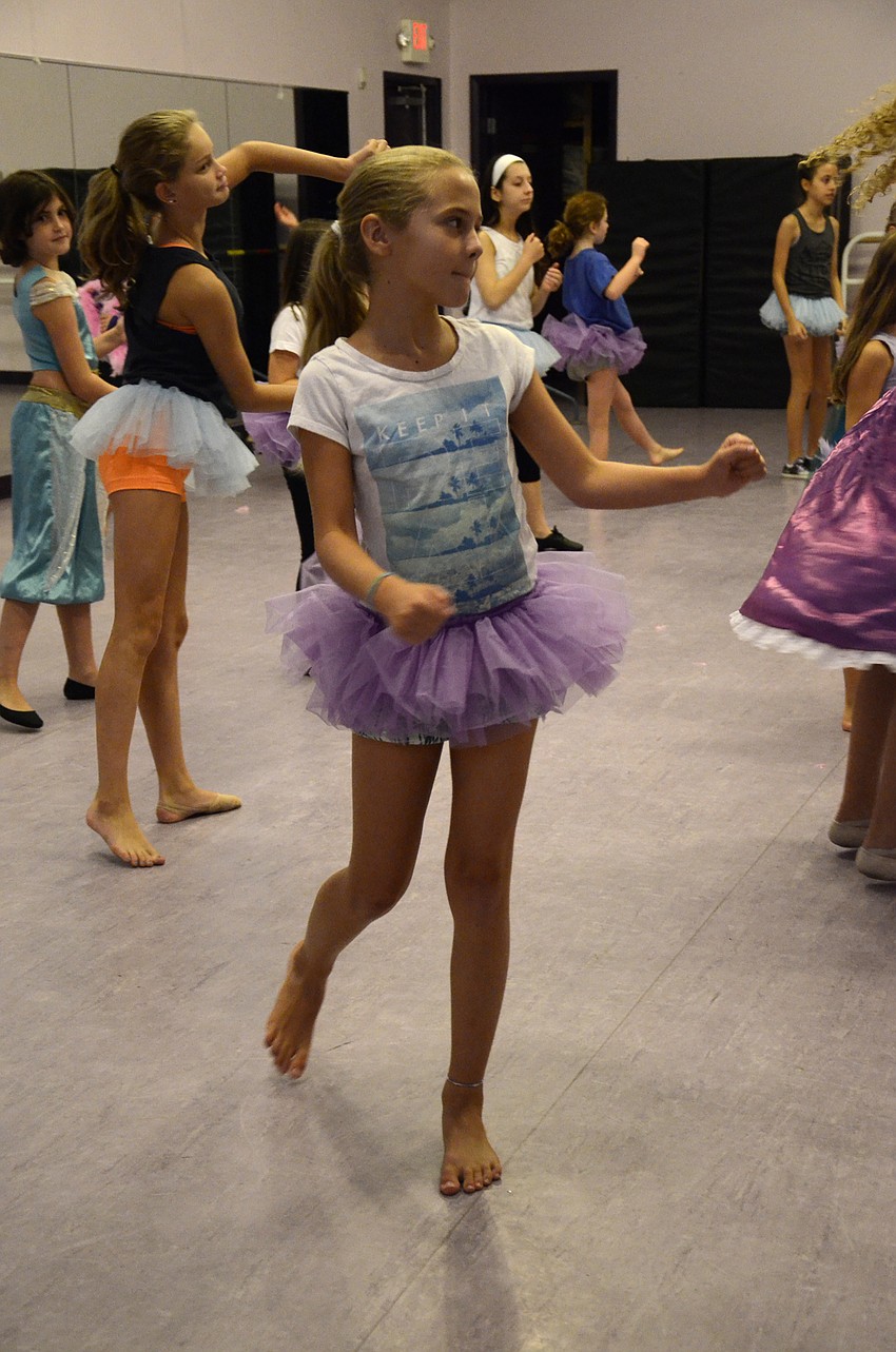 Danielle Kirchberg, 10, dances while she sweeps like Cinderella.