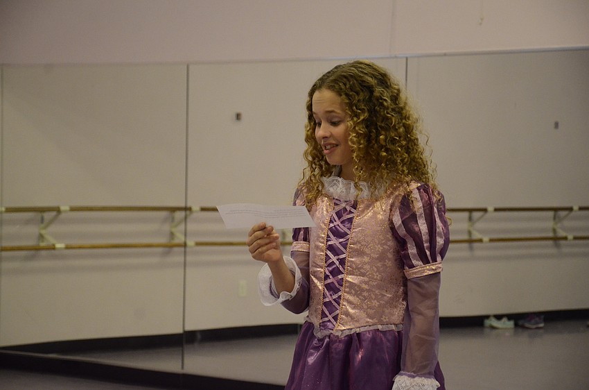 Belle Babcock, 12, practices reading a Disney fact for the performance.