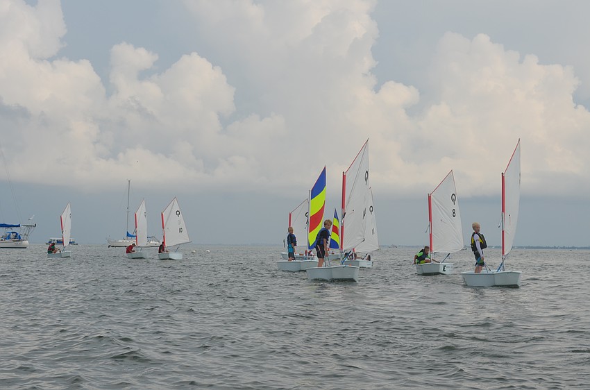 Campers learn how to control a sailboat sitting, lying and standing.