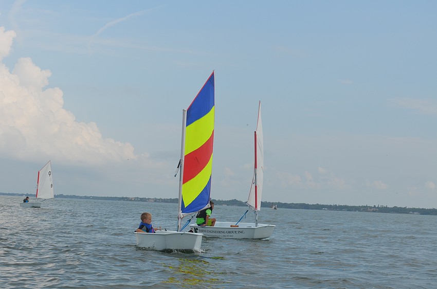Campers learn how to control a sailboat sitting, lying and standing.
